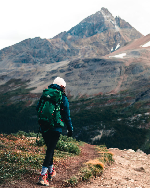 young lady hiking with mountaineering apparel in snow covered mountains