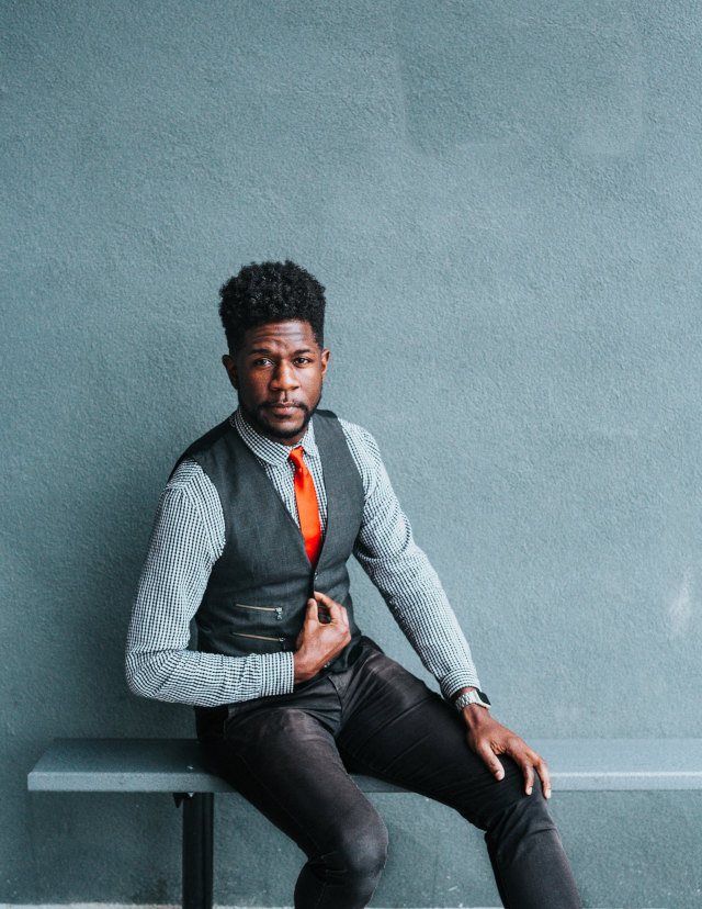 young man sitting on a bench with a stylish suit vest